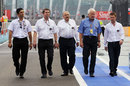 The FIA stewards and Charlie Whiting walk down the pit lane