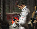 Michael Schumacher watches from the sidelines after crashing out of the race