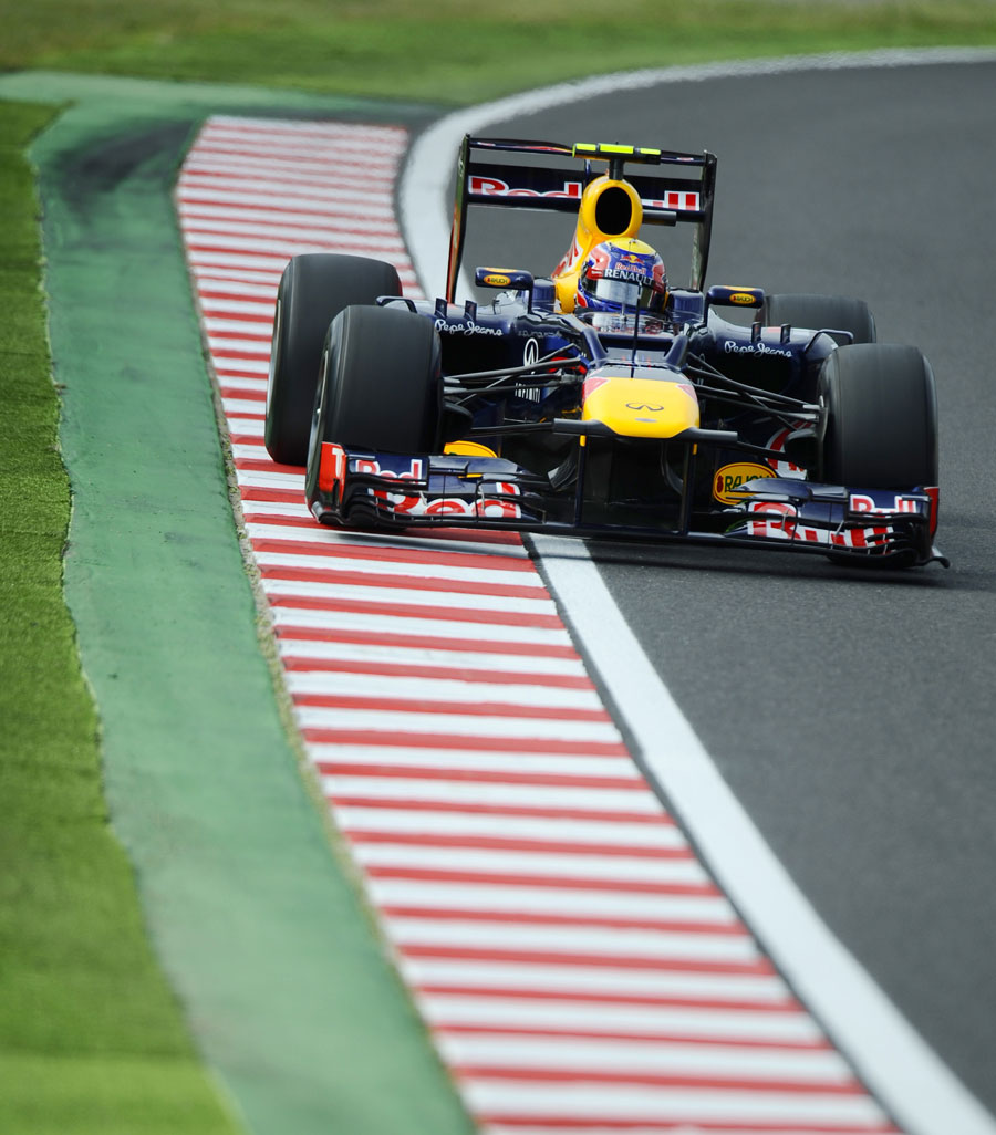 Mark Webber uses the kerbs on the exit of the corner