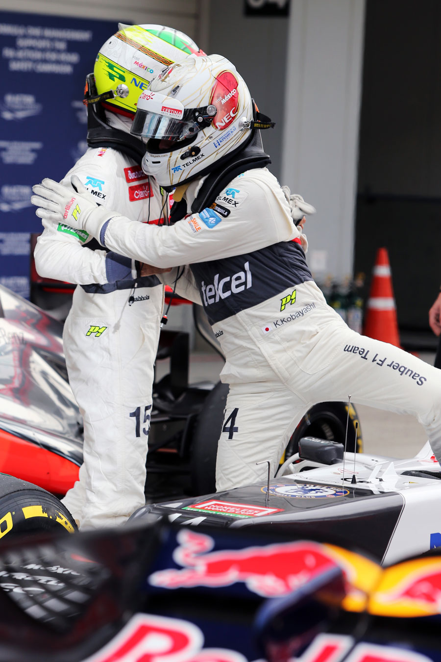 Kamui Kobayashi is congratulated by Sergio Perez in parc ferme