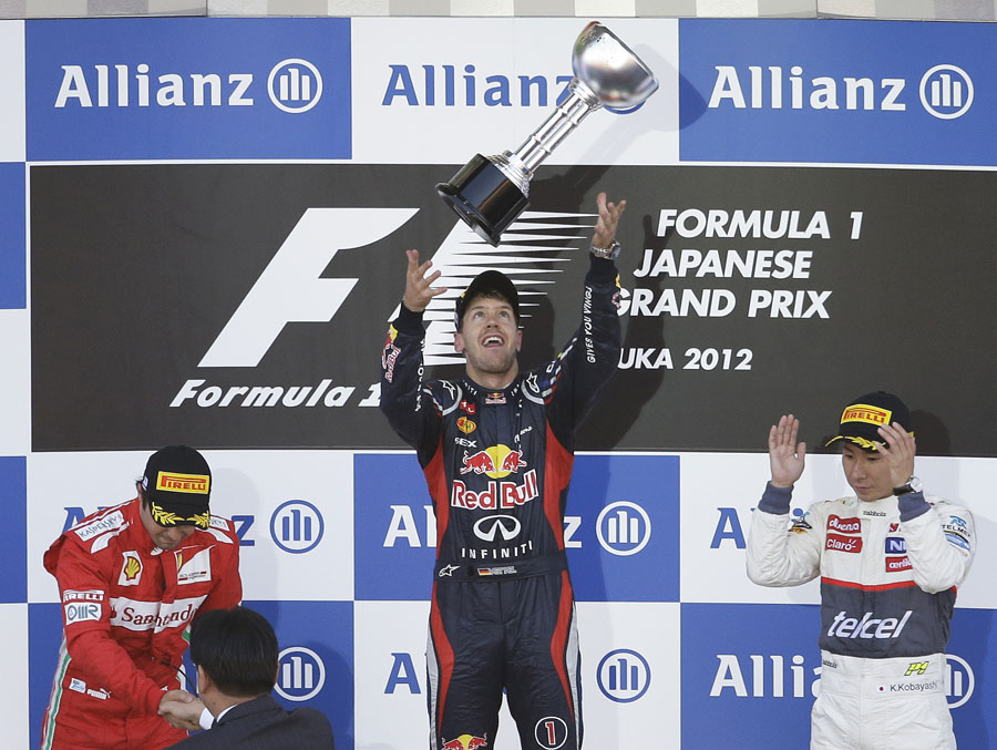 Sebastian Vettel celebrates his victory alongside Felipe Massa and Kamui Kobayashi on the podium