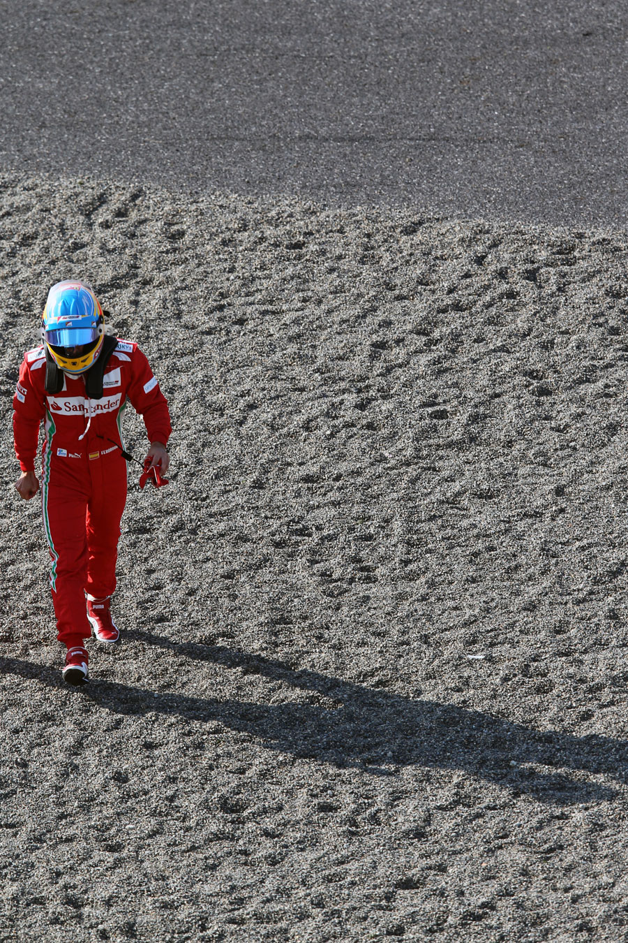Fernando Alonso walks away from his car after spinning out at turn one