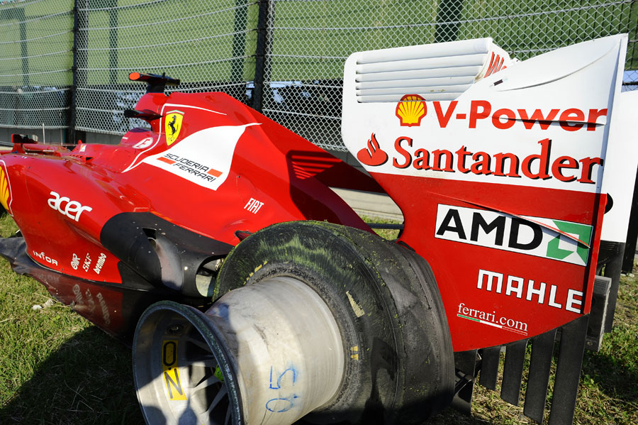 Fernando Alonso's Ferrari on the outside of turn one after he retired with a puncture