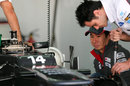 Kamui Kobayashi watches his mechanics prepare his car