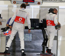 Jenson Button and Lewis Hamilton report to the FIA weighing scales after qualifying