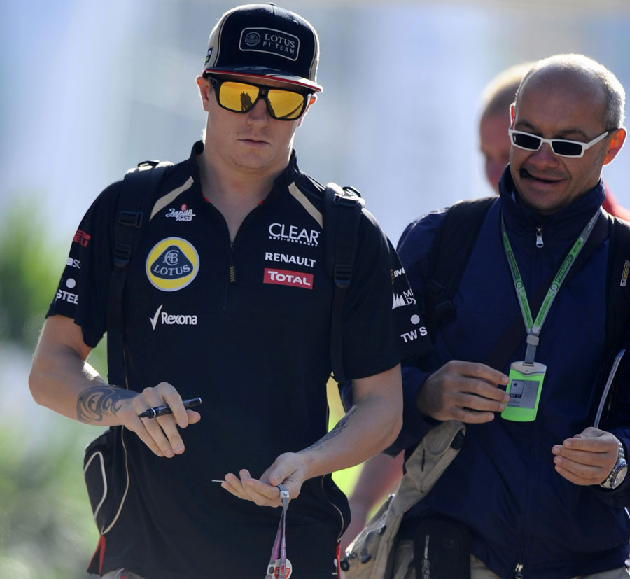 Kimi Raikkonen signs an autograph in the paddock
