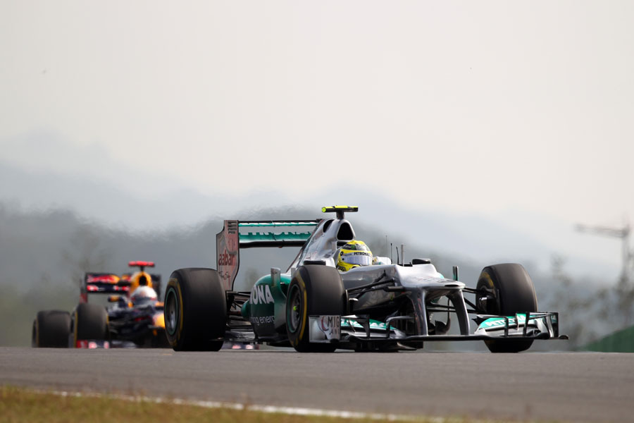 Nico Rosberg crests a hill with Sebastian Vettel close behind