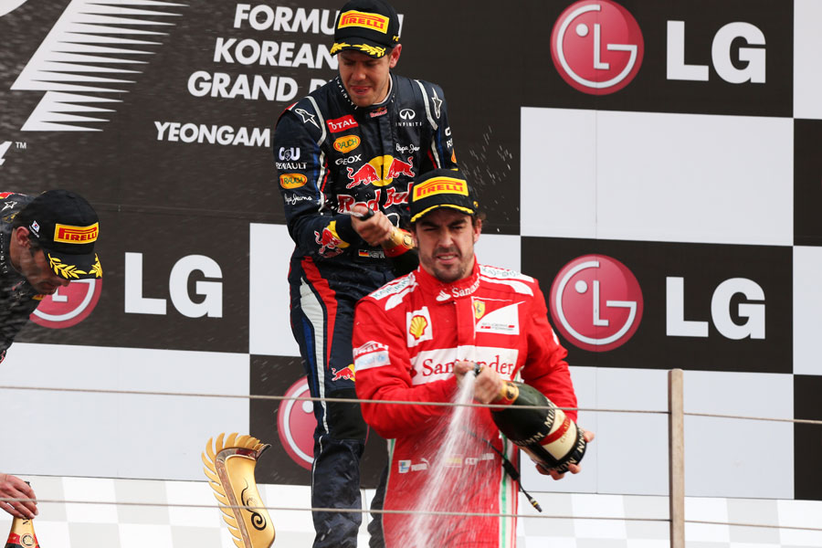 Sebastian Vettel and Fernando Alonso spray champagne on the podium