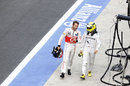 Jenson Button and Nico Rosberg walk back to the pits together after being taken out on lap 1