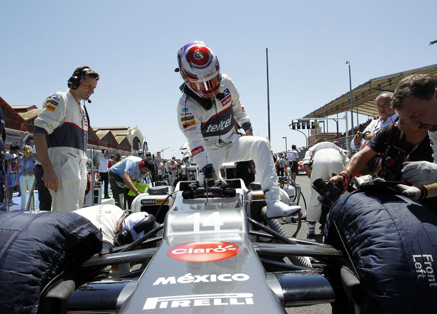 Kamui Kobayashi steps out of his car on the grid