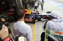 Lewis Hamilton watches on as Mark Webber leaves the pits