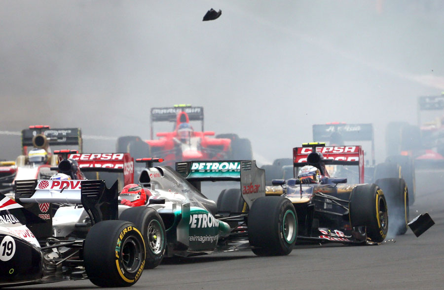 Jean-Eric Vergne loses part of his front wing against Michael Schumacher's Mercedes