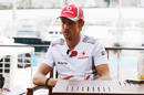 Jenson Button talks to the press in the paddock