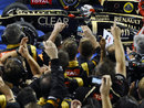 Kimi Raikkonen stops in parc ferme in front of a celebrating Lotus team