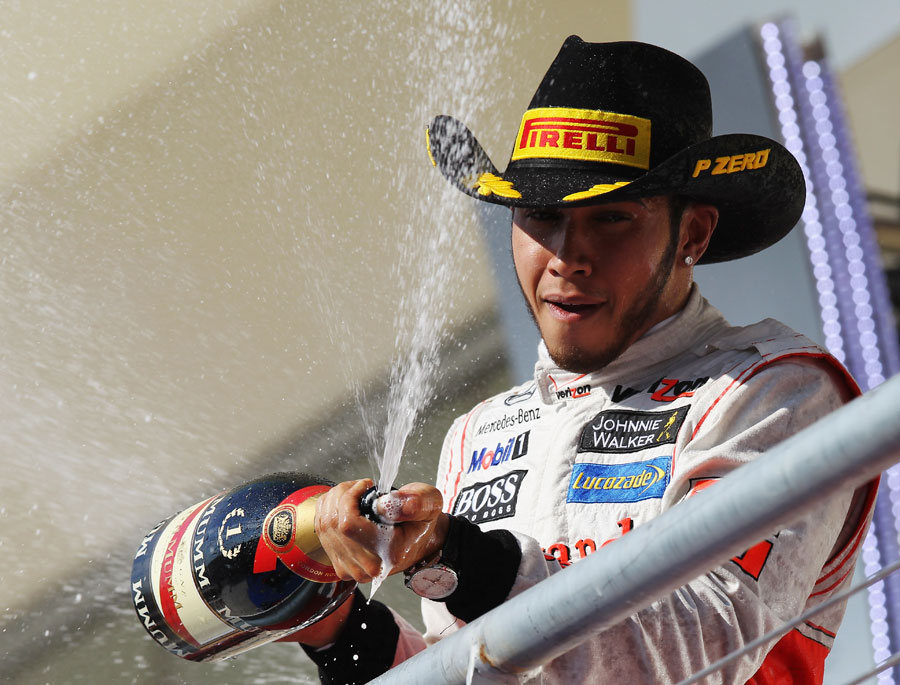 Lewis Hamilton celebrates on the podium after taking victory