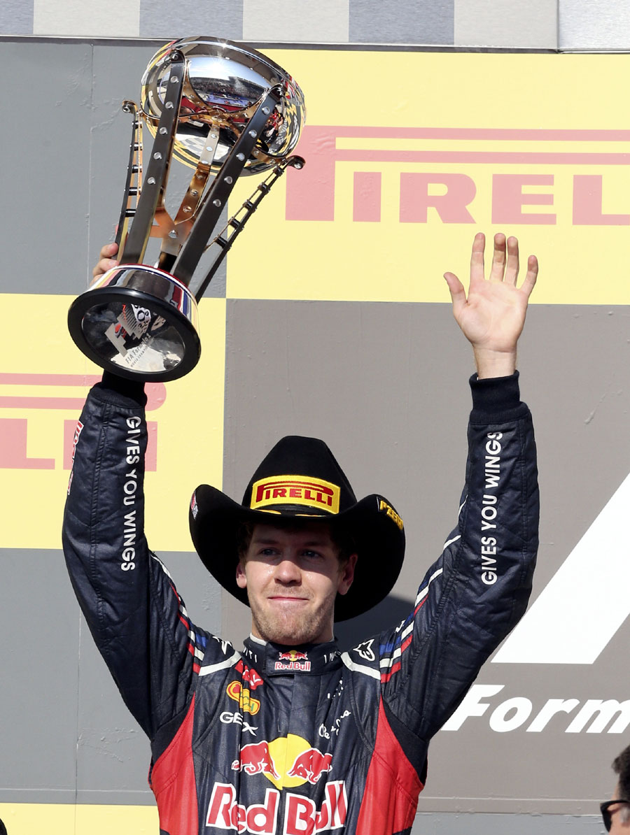 A stetson-wearing Sebastian Vettel celebrates on the podium