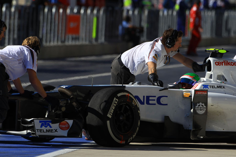 Sergio Perez is wheeled back in to the Sauber garage