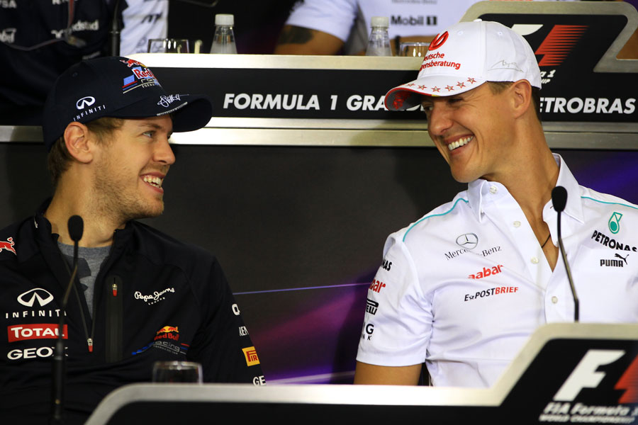 Michael Schumacher and Sebastian Vettel share a joke in the driver press conference
