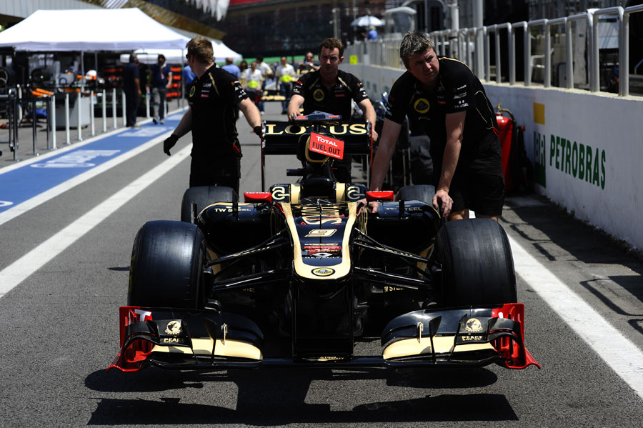 A Lotus E20 is pushed down the pit lane