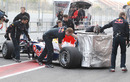 Red Bull push Mark Webber's car back into the garage
