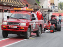 Fernando Alonso's Ferrari is towed back to the pits