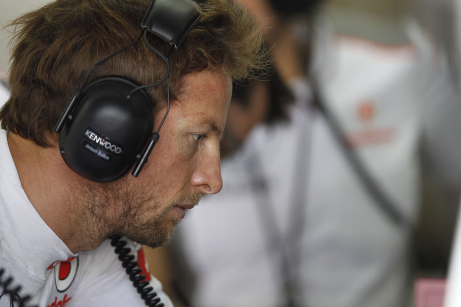 Jenson Button studies data in the McLaren garage