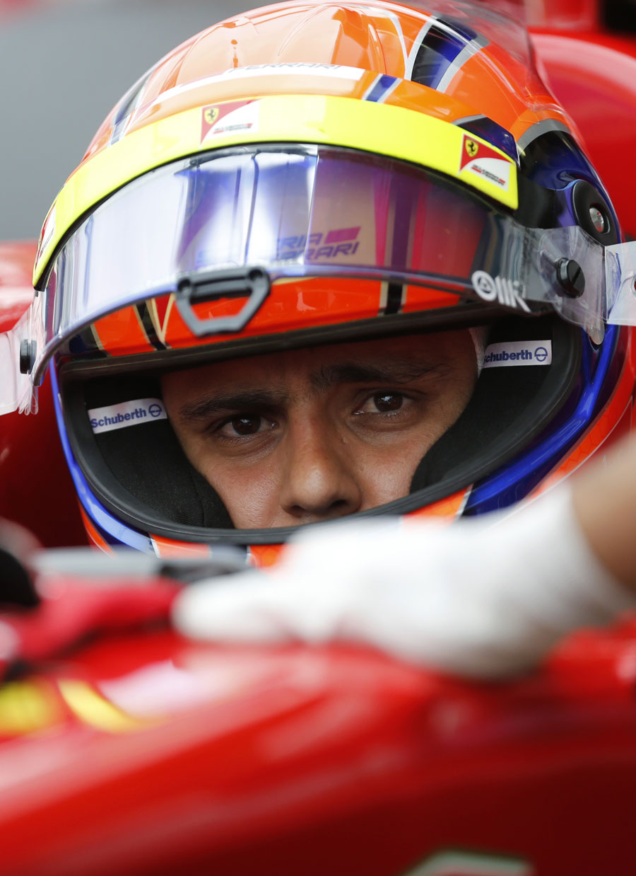 A pensive Felipe Massa is wheeled back in to the Ferrari garage