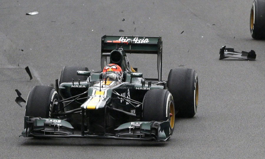 Heikki Kovalainen drives over fragments of a car 