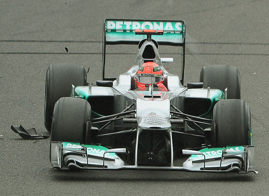 Michael Schumacher drives over debris on his way to seventh place in his final race