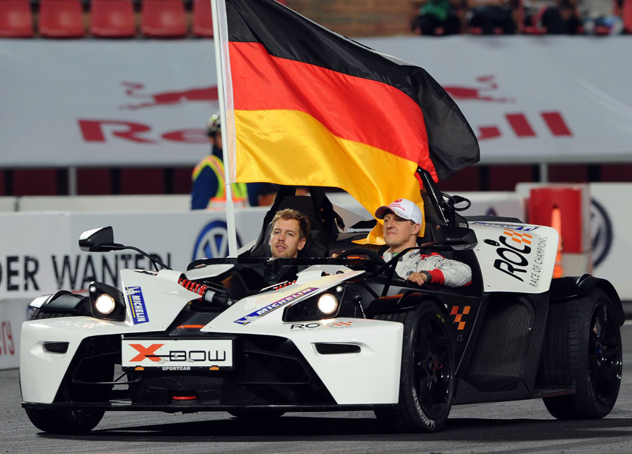 Sebastian Vettel and Michael Schumacher drive a victory lap at the Race of Champions