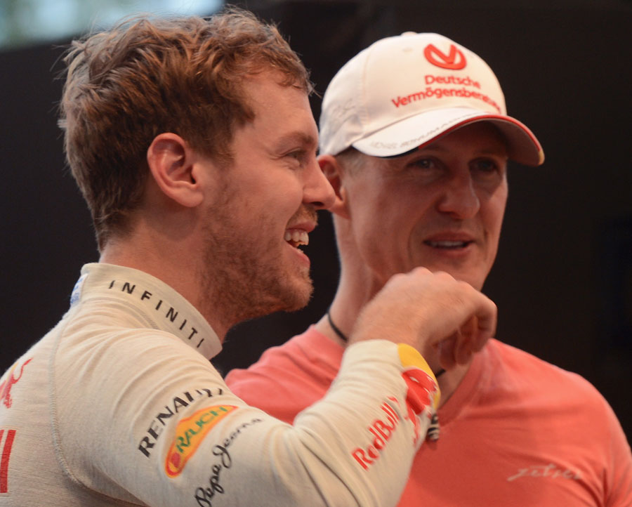 Sebastian Vettel and Michael Schumacher share a joke at the Race of Champions