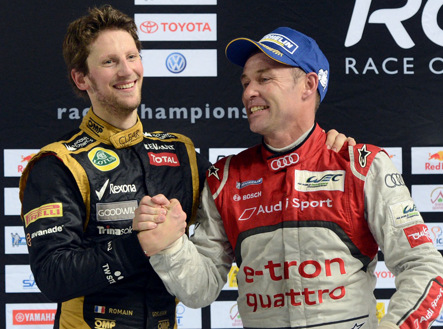 Romain Grosjean celebrates on the podium after beating Tom Kristensen in the Champion of Champions event at the Race of Champions