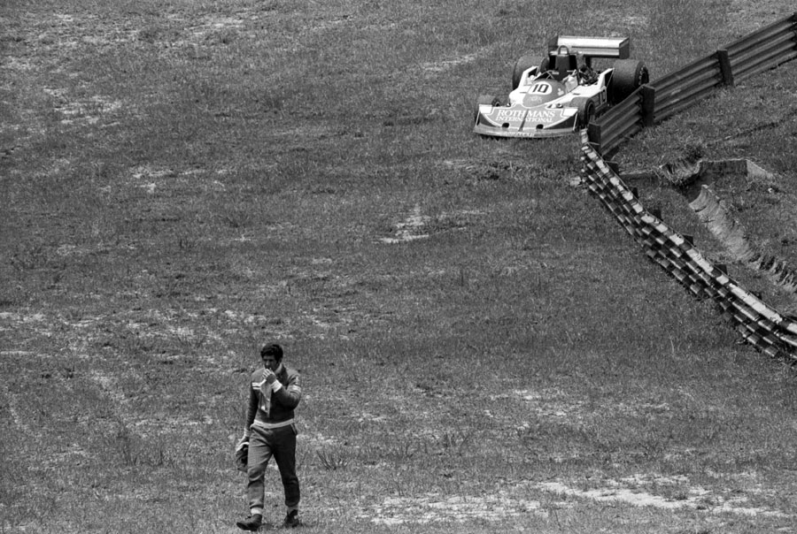Jody Scheckter retires from the race with his brother Ian's stricken car in the background
