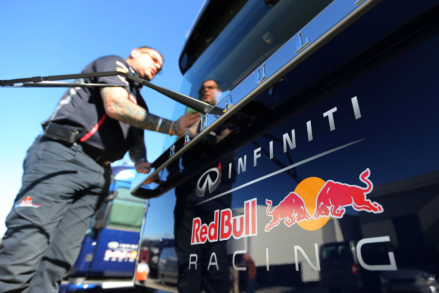 A Red Bull mechanic cleans a team transporter