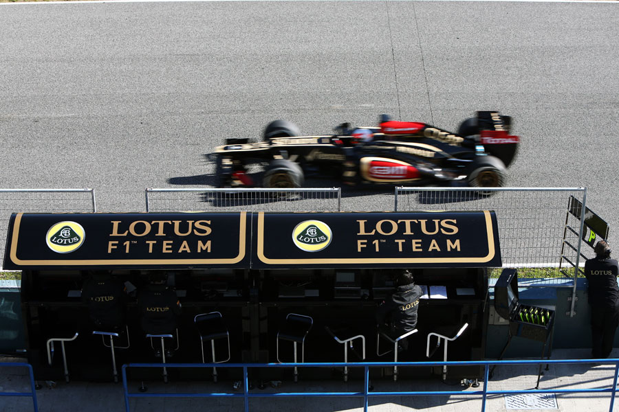 Romain Grosjean flashes past the Lotus pit wall