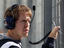 Sebastian Vettel watches on from the pit wall