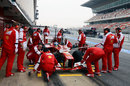 The Ferrari pit crew gather around Fernando Alonso's car