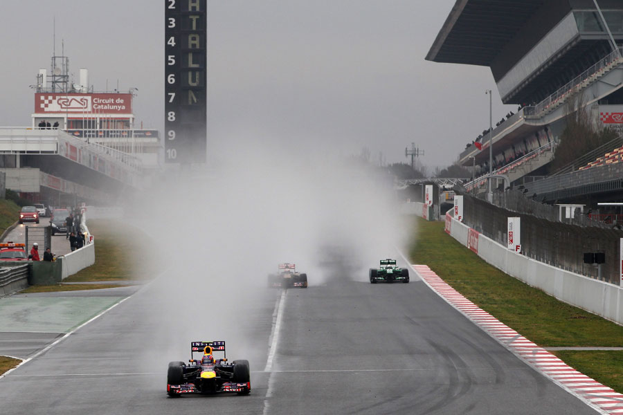 Mark Webber exits the pits leaving spray in his wake