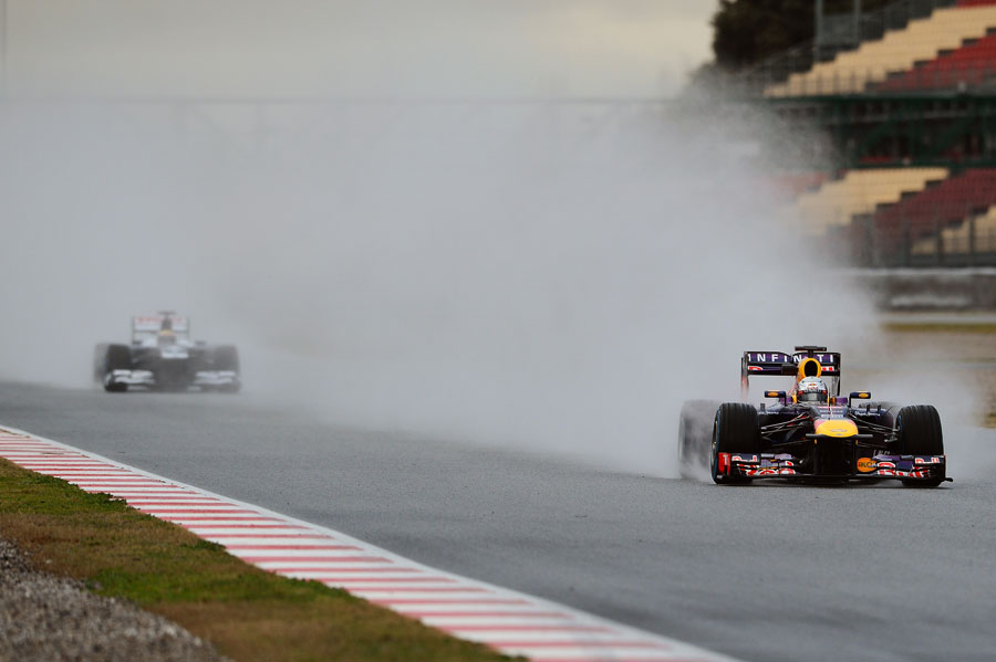 Sebastian Vettel leaves Pastor Maldonado in a cloud of spray