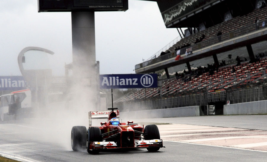 Fernando Alonso leaves the pits on full wet tyres