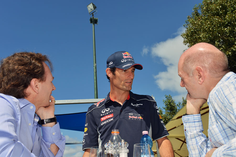 Mark Webber speaks to Christian Horner and Adrian Newey in the paddock