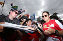 Felipe Massa signs autographs as he arrives in the paddock