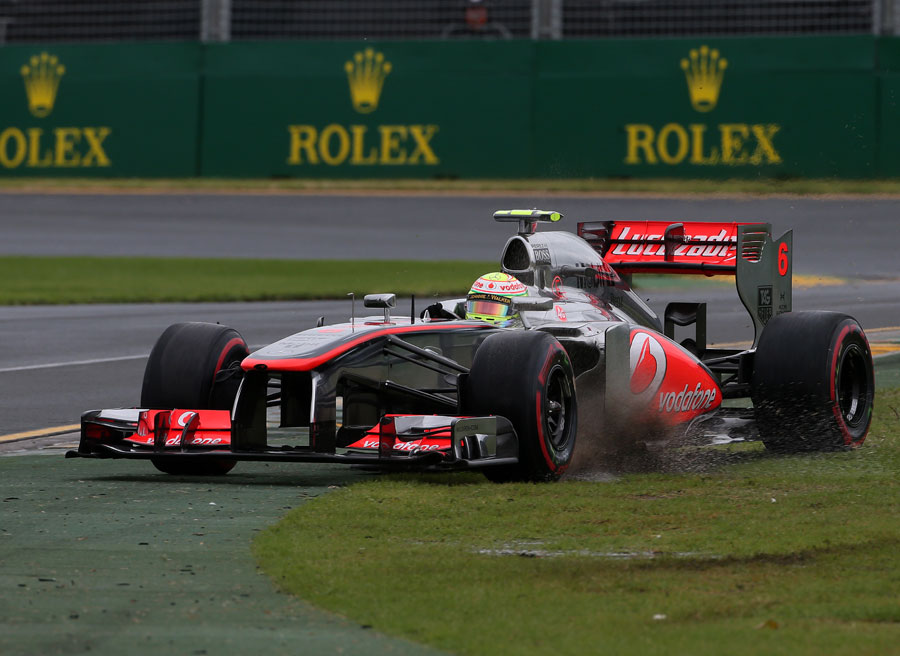 Sergio Perez runs wide as he struggles with slick tyres on a damp track