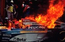 Eddie Irvine's Jordan goes up in flames during a pit stop