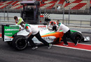 Adrian Sutil's Force India is pushed back into the garage