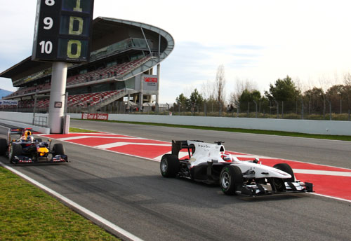 Kamui Kobayashi leads Sebastian Vettel out onto the track