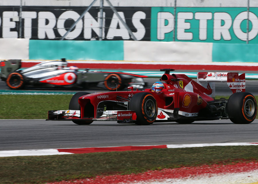 Fernando Alonso tackles turn two, followed by Jenson Button