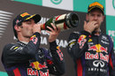 Sebastian Vettel watches on from the top step of the podium as a fuming Mark Webber takes a swig of champagne