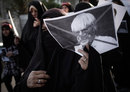 A Bahraini woman holds a cross-marked picture of Bernie Ecclestone 