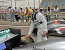 Lewis Hamilton inspects the damage to the rear of his Mercedes after a suspected tyre failure